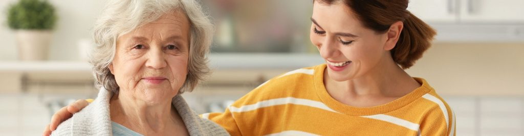 Carer helping older lady who is smiling